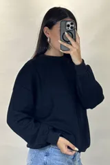 Buzo de cuello redondo, corte oversize, con mangas largas y puños elásticos.