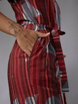 Mono de lino mezcla con estampado vegetal en tonos rojos, grises y blancos, de manga corta, escote en V y piernas amplias con cinto incorporado para ajustar la cintura.
