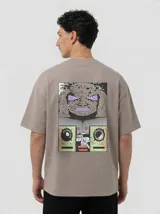 Remera de algodón color gris topo con corte relajado. Presenta un diseño gráfico estampado en la espalda que combina una figura abstracta con parlantes en tonos violeta y verde ácido.