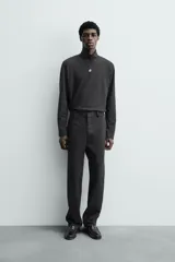 Pantalón chino de corte oversized confeccionado en tejido de algodón con estructura twill. Presenta bolsillos frontales, bolsillos traseros de vivo y cierre frontal con cremallera y gancho metálico oculto.