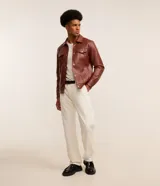 Pantalón recto de sarga color blanco roto, con cintura con trabillas, cierre frontal tradicional y bolsillos laterales y traseros.