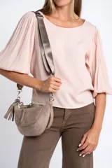 Blusa color rosa pálido, de manga larga abullonada con puño elástico y escote redondo.