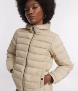 Campera ultra leve Blue Steel, confeccionada en poliamida, con diseño de gajos, capucha, cierre frontal por cremallera, bolsillos laterales con botones y elástico en los puños.