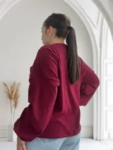 Sweater de punto color borgoña, de corte holgado y mangas largas.