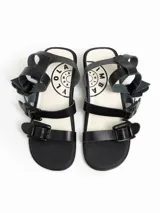 Sandalias negras de cuero con tacón bajo y tiras anchas con hebillas.