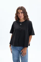 Remera negra de manga corta con corte evasé, que se ensancha ligeramente hacia el bajo.