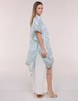 Kimono de gasa ligera con estampado floral en tonos de azul y blanco, silueta amplia, mangas cortas y detalle de borlas en el ruedo asimétrico.