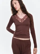 Remera de dormir entallada de viscosa, color bordó, con escote en V profundo adornado con encaje al tono y mangas largas.