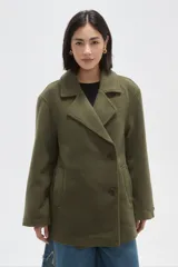 Chaqueta de paño color verde militar, con cuello solapa, cierre frontal con botones y bolsillos laterales. De diseño holgado y manga larga.