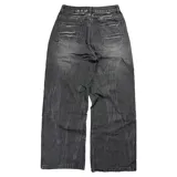 Pantalón de jean estilo baggy fit, color negro con efecto lavado y detalles de roturas horizontales en la parte frontal. Presenta un corte holgado y tiro bajo.