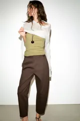Pantalón de tiro medio con diseño barrel, pernera holgada que se estrecha hacia el tobillo, bolsillos delanteros y bolsillos de plastrón en la espalda. Confeccionado en tejido con textura de espiga, cuenta con cierre frontal de cremallera, botón interior y gancho.
