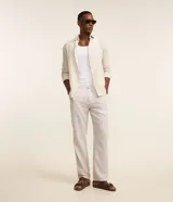 Pantalón de sastrería corte recto para hombre, color beige, confeccionado en mezcla de lino y algodón. Posee trabillas en la cintura, cierre tradicional y bolsillos laterales.