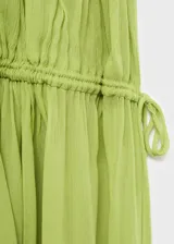 Vestido maxi largo de tejido plisado color verde, con tirantes finos, cuello escotado y cintura fruncida con elástico.