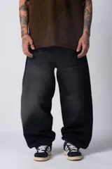 Pantalón de jean estilo baggy con corte amplio y holgado, de color negro con efecto lavado. Presenta una silueta relajada y tiro medio.