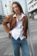 Camisa de corte oversized, color blanco, con cuello clásico, cierre frontal de botones y mangas largas.