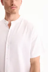 Camisa de lino de manga corta, color blanco, con cuello mao y cierre frontal de botones.
