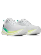 Championes de running Under Armour modelo Velociti, color gris claro con detalles en verde neón y amarillo. Presentan un diseño minimalista con tejido superior elástico, entresuela de espuma reactiva y suela de goma duradera.