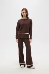 Sweater de tejido de punto color marrón, de corte holgado y cuello redondo, con detalle de franja horizontal en color crema en la parte inferior.