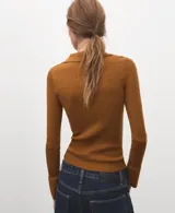 Jersey de punto color mostaza, con cuello polo y cierre frontal parcial de botones, de manga larga y diseño ajustado.