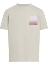 Remera color crema de corte recto, con cuello redondo y mangas cortas. Presenta un estampado cuadrado en el pecho con degradado de color y el logo de Calvin Klein.