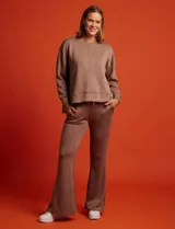 Buzo blanco de tejido elastizado, con pespunte central en la parte delantera y tajos laterales.