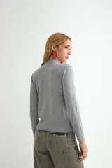 Polera de tejido de punto fino color bordó, con cuello alto y mangas largas.