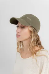 Gorra verde militar de diseño clásico con visera curva y aplique metálico plateado con la inscripción "Peach" en el lateral frontal. Cuenta con tira ajustable en la parte trasera.
