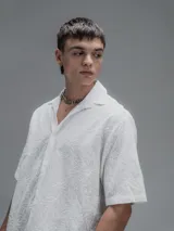 Camisa blanca de manga corta, con cuello abierto y calce oversize. Confeccionada en algodón bordado tipo broderie con diseño floral.