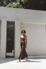 Vestido largo semitransparente confeccionado en encaje suave, con escote redondo, tirantes finos ajustables y bajo con acabado en ondas.