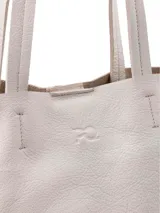 Cartera tipo shopper color crudo, confeccionada en cuero, de diseño amplio y sin forro con terminaciones al corte. Cuenta con doble asa de hombro y bolsillo interior con cierre.