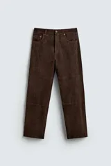 Pantalón de corte straight fit confeccionado en ante de color marrón, con diseño de cinco bolsillos y cierre frontal con cremallera y botón.