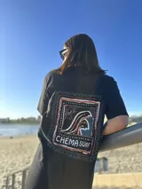 Remera color crema de algodón con estampa en la espalda de un paisaje playero con el texto "Chema Sure Chate et la mer".