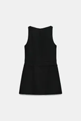 Vestido mono corto de cuello redondo y sin mangas. Presenta un diseño entallado con detalle de cinturón del mismo tejido con hebilla metálica y cierre de cremallera oculta en la espalda.