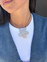 Chaleco de jean azul con cierre frontal mediante lazos ajustables, sin mangas y corte recto.