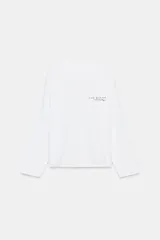 Camiseta blanca de manga larga con cuello redondo y texto bordado en color rojo en el pecho.