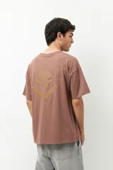 Remerón unisex verde militar de manga corta y cuello redondo, con pequeño estampado lateral en el frente y otro grande en la espalda.