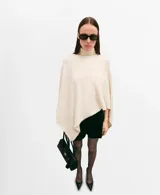 Poncho de tejido de punto color marfil, con cuello alto vuelto y diseño amplio con aberturas para los brazos.