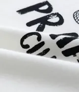 Remera blanca de algodón con estampa de una figura femenina con un blazer a rayas y un bolso de mimbre.