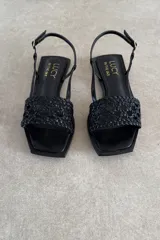 Sandalias chatas de cuero negro, marca Lucy in the Sky, con tira delantera trenzada, puntera cuadrada y tira ajustable al talón.