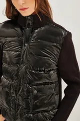 Campera híbrida de diseño moderno, con frente acolchado tipo puffer en acabado brillante y mangas tejidas en punto acanalado. Presenta cuello alto tejido y cierre frontal con botones a presión.