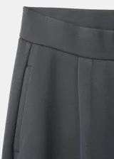 Pantalón de piqué color gris oscuro, de corte recto y holgado con pinzas en la parte delantera y cintura elástica.
