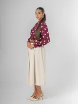 Falda midi de corte clásico confeccionada en corderoy, con cintura elastizada, diseño de tablas y bolsillos laterales. Incluye un cinturón desmontable en color marrón.