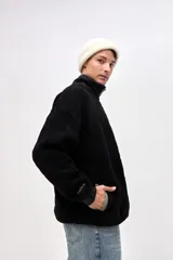 Buzo de sherpa doble faz con textura capitoneada, color negro. Presenta cuello alto con medio cierre, bolsillos laterales, puños elásticos y detalles en nylon. Incluye bordado en la manga y el cuello.