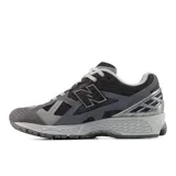 Championes urbanos New Balance modelo 1906U, con diseño inspirado en el running de los años 2000. Presentan una combinación de tonos grises y negros, con empeine de material sintético y malla, entresuela con tecnología ACTEVA LITE y amortiguación ABZORB SBS en el talón.