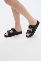 Sandalias planas color negro con efecto croco, doble tira en el empeine con hebillas metálicas plateadas y suela anatómica.