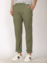 Pantalón de lino color verde oliva, de corte recto y con ruedo arremangado.