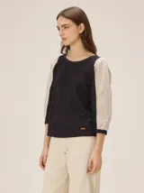 Blusa de diseño combinado con cuerpo delantero y espalda de algodón negro, y mangas abullonadas tres cuartos de lino en color beige con puños elásticos negros.