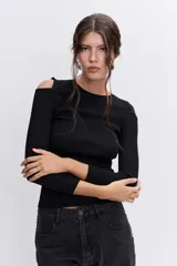 Pantalón de jean negro de corte recto y tiro alto, con detalle de botones metálicos plateados a lo largo de la costura lateral externa.