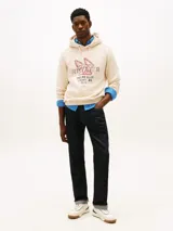 Buzo canguro Tommy Hilfiger de color blanco, con capucha ajustable por cordones y diseño gráfico deportivo en el pecho. Presenta un estilo urbano y relajado.