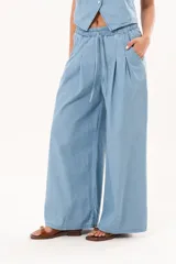 Pantalón de pierna súper amplia, confeccionado en denim fino y liviano, de tiro alto, con cintura elastizada, lazo regulable y bolsillos laterales.